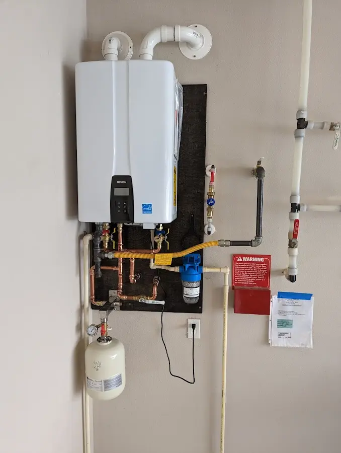 Professional plumber installing copper piping in a Narragansett home